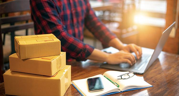 eCommerce shipping boxes next to a laptop displaying a website for driving customer traffic